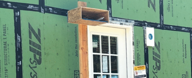 Wooden birdhouse mounted above mudroom door during custom home construction in Connecticut, part of Caulkins Homes’ conservation efforts